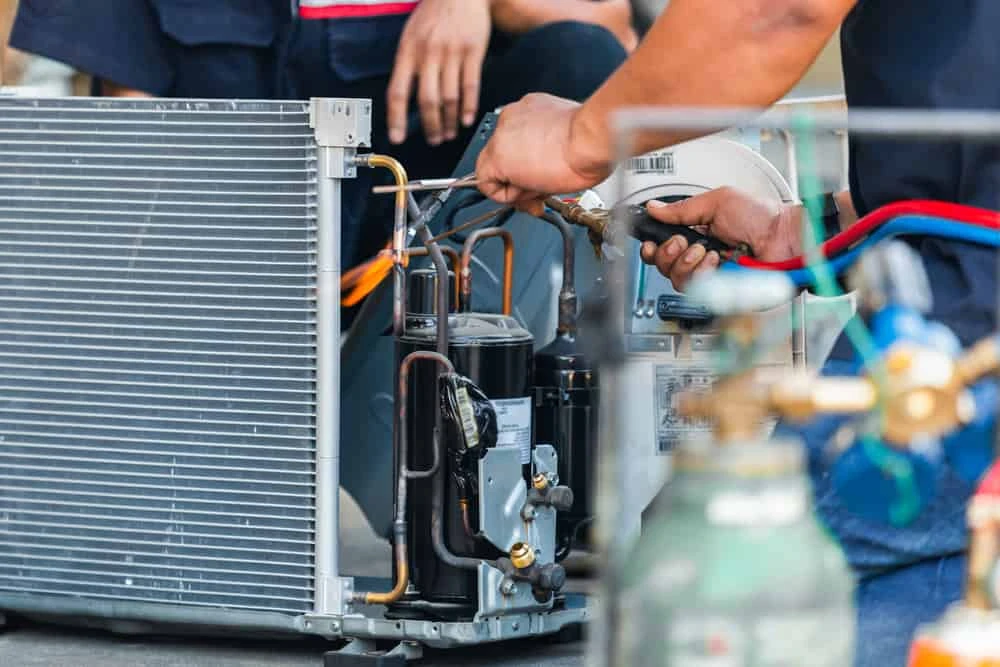 Close-up of technicians repairing air conditioning components